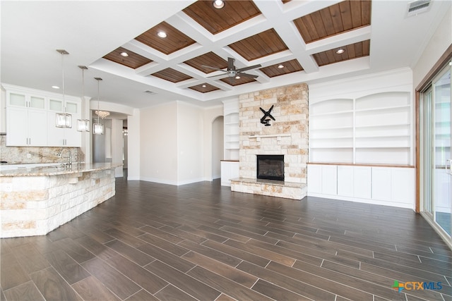 unfurnished living room with a fireplace, beam ceiling, dark hardwood / wood-style floors, and coffered ceiling