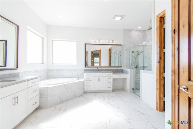 bathroom with vanity and shower with separate bathtub