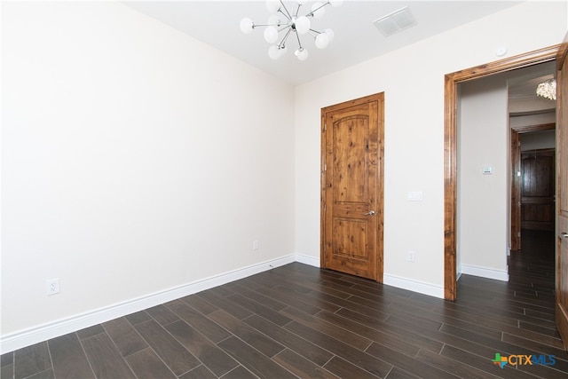 unfurnished bedroom featuring a notable chandelier and dark hardwood / wood-style floors