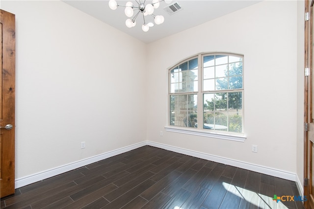 unfurnished room featuring a notable chandelier and dark hardwood / wood-style floors