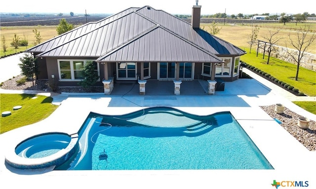 back of property featuring a pool with hot tub, a patio area, and a rural view