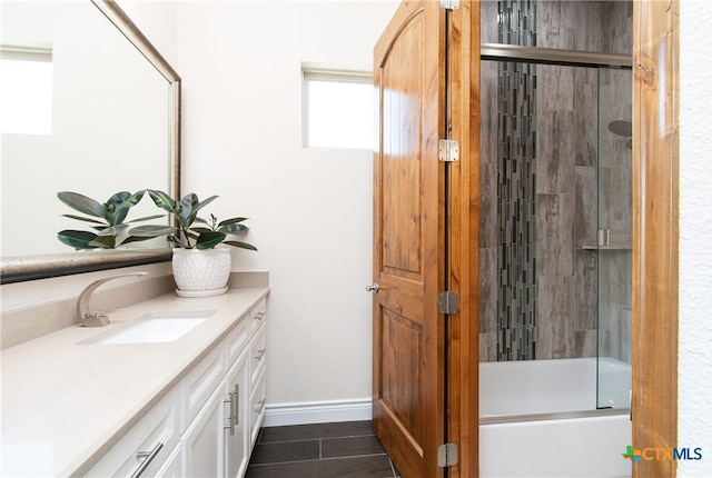 bathroom featuring bath / shower combo with glass door and vanity