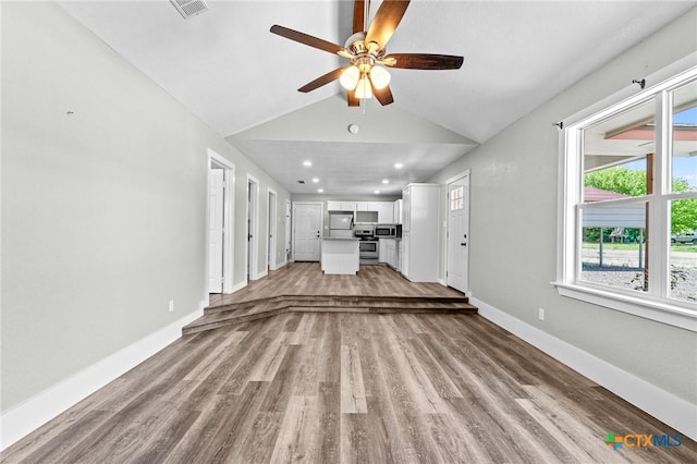 unfurnished living room with visible vents, baseboards, a ceiling fan, light wood finished floors, and vaulted ceiling