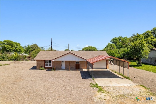 view of front of house with a carport, driveway, and brick siding