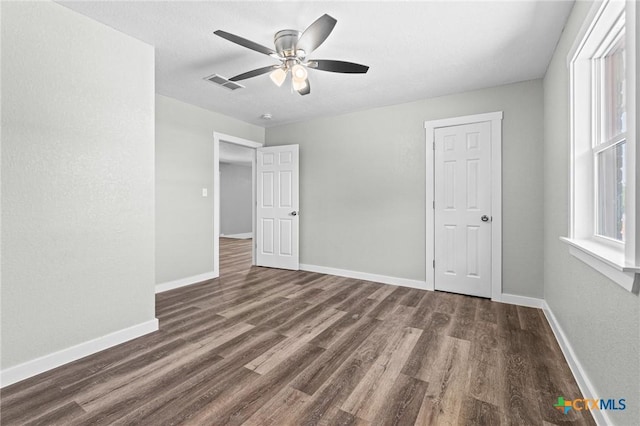 unfurnished bedroom with ceiling fan, baseboards, visible vents, and wood finished floors