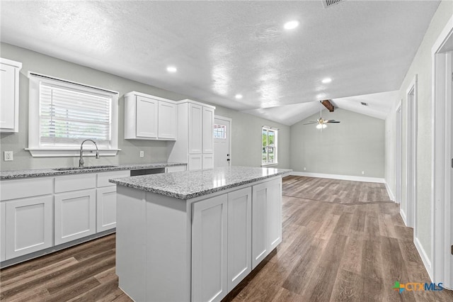 kitchen featuring white cabinets, dark wood-style flooring, a textured ceiling, and a sink