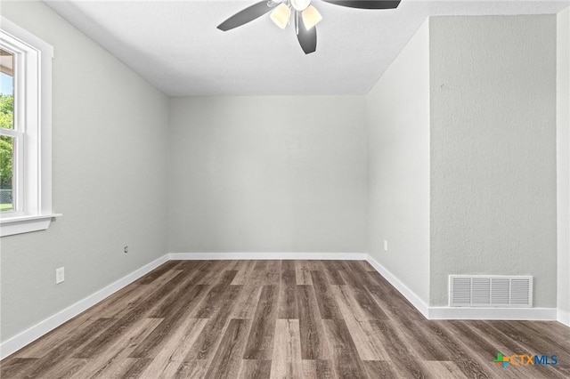 unfurnished room with a ceiling fan, baseboards, visible vents, and wood finished floors