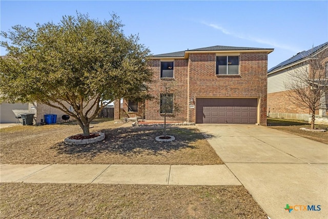 traditional-style house with concrete driveway, brick siding, and an attached garage