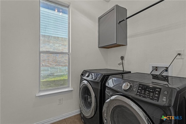 clothes washing area with washer and dryer, baseboards, tile patterned flooring, and cabinet space
