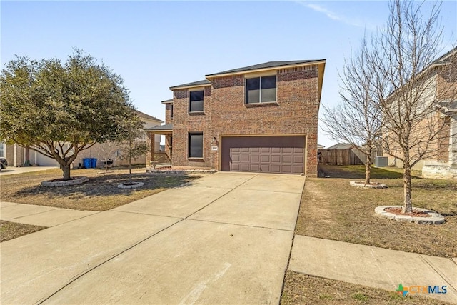 traditional home featuring concrete driveway, brick siding, an attached garage, and fence