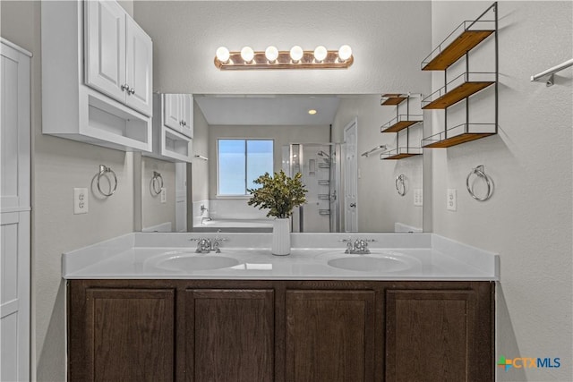 full bath featuring an enclosed shower, double vanity, and a sink