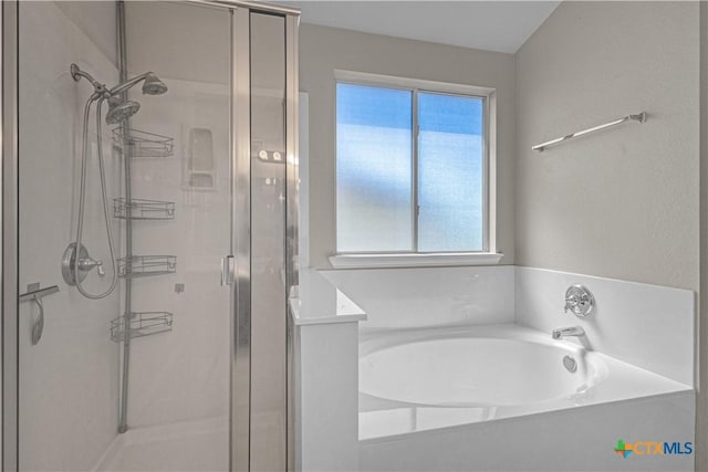 bathroom featuring a shower stall and a bath