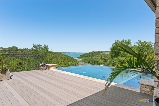outdoor pool featuring a deck with water view