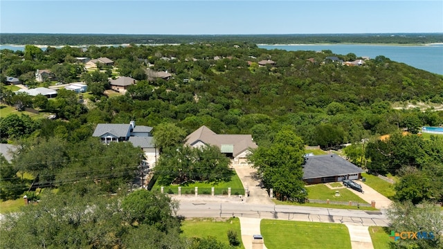 drone / aerial view of a heavily wooded area and a nearby body of water