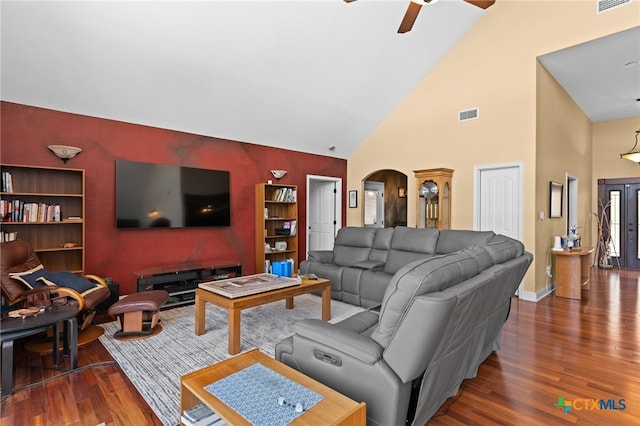 living area with wood finished floors, high vaulted ceiling, ceiling fan, arched walkways, and baseboards