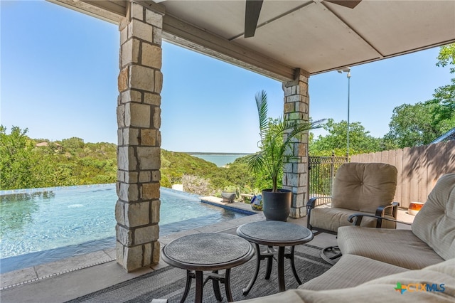 view of patio / terrace with an outdoor pool and a water view