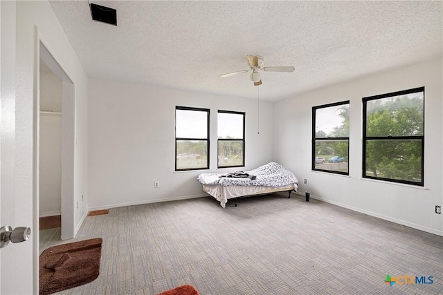 bedroom featuring carpet floors, a textured ceiling, baseboards, and a ceiling fan