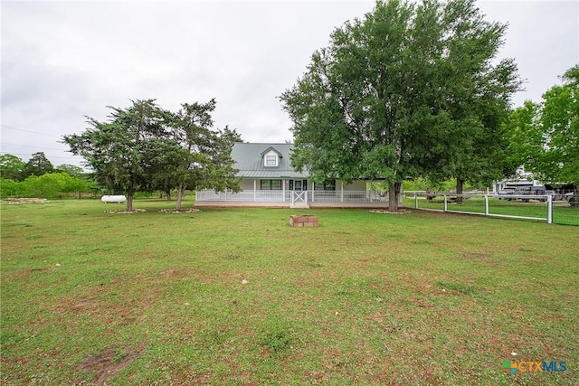 view of green lawn with covered porch