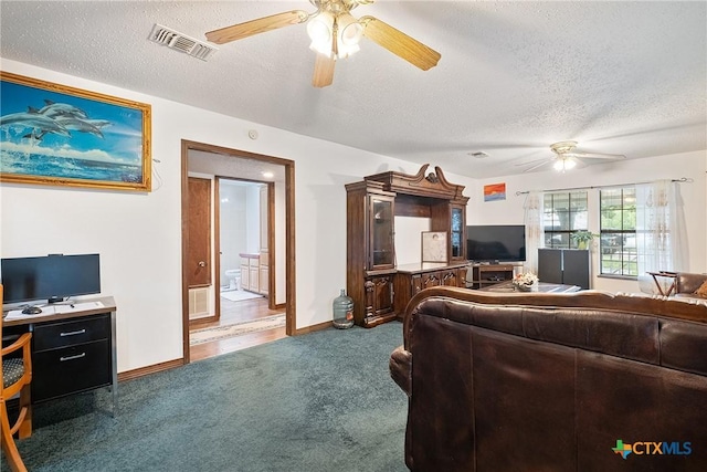 living area with a ceiling fan, carpet floors, a textured ceiling, and baseboards
