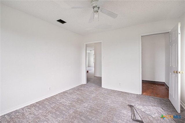 unfurnished bedroom with carpet flooring, baseboards, ceiling fan, and a textured ceiling