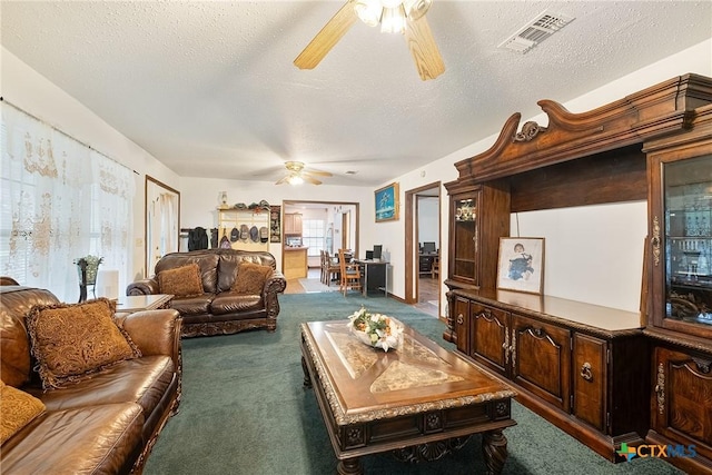 carpeted living area with a ceiling fan and a textured ceiling