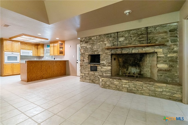 unfurnished living room with a fireplace and light tile patterned flooring