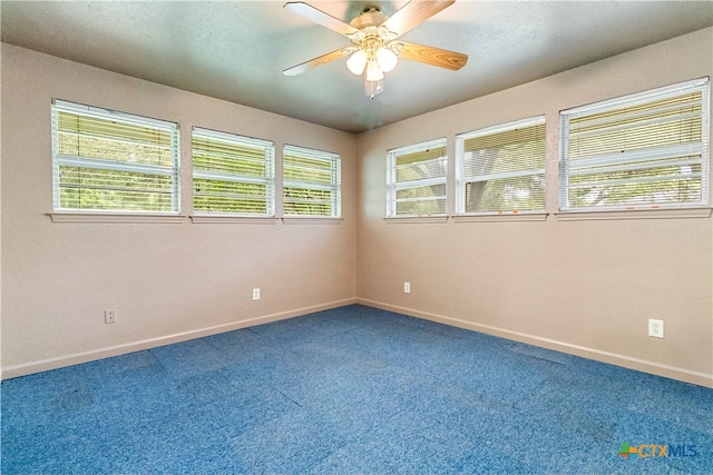 unfurnished room with carpet flooring, a wealth of natural light, and ceiling fan