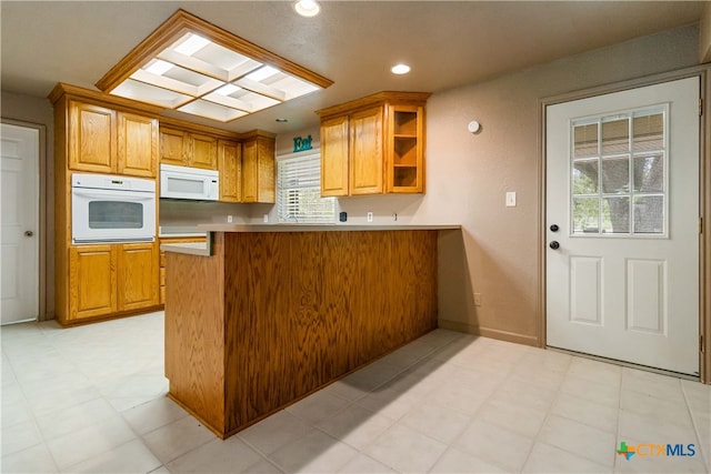 kitchen featuring white appliances and kitchen peninsula