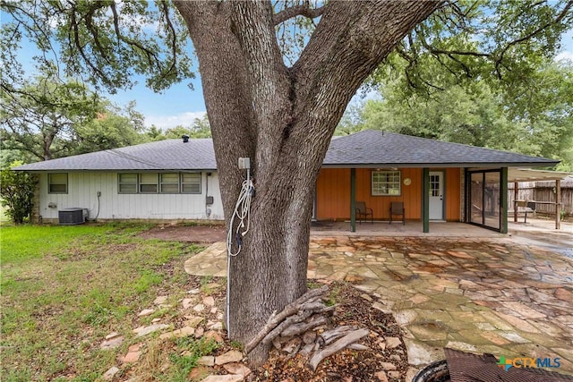 view of front of house featuring a front yard, cooling unit, and a patio area