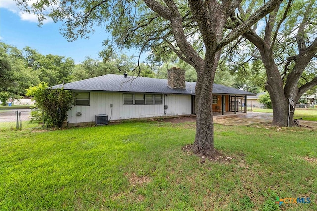 back of house with a patio, a lawn, and central AC