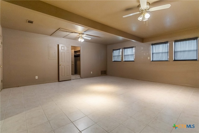 empty room featuring beamed ceiling and ceiling fan