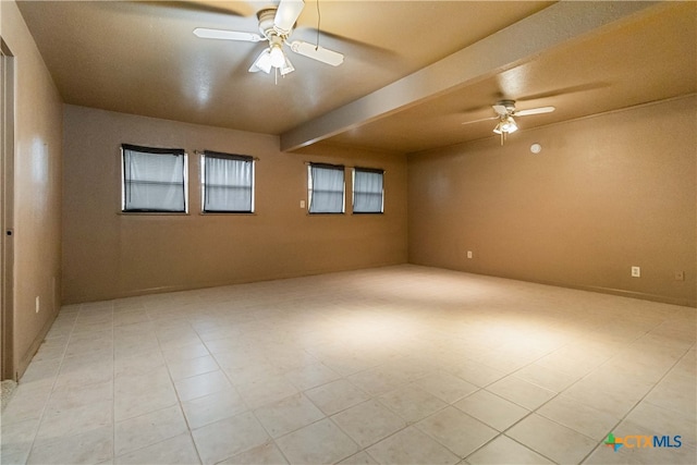 spare room with ceiling fan and beam ceiling