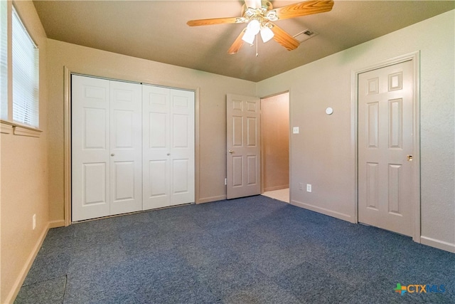 unfurnished bedroom with ceiling fan and dark carpet