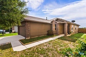 single story home with a front yard and a garage