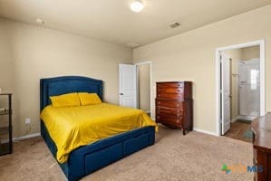 carpeted bedroom with connected bathroom