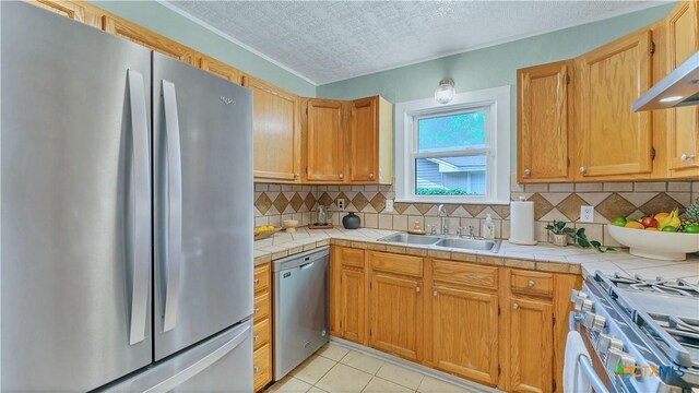 1261 W Mill St, New Braunfels, TX 78130 - kitchen with stainless steel appliances, tile counters, backsplash, light tile patterned floors, and ventilation hood