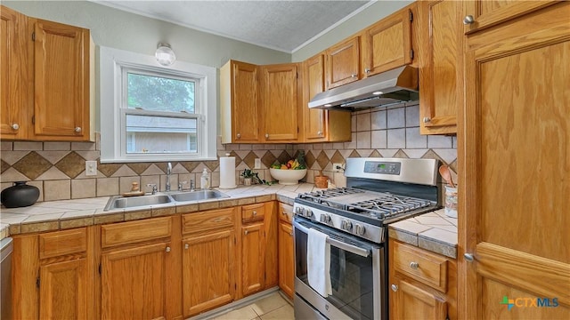 1261 W Mill St, New Braunfels, TX 78130 - kitchen featuring gas range, under cabinet range hood, tile countertops, ornamental molding, and tasteful backsplash