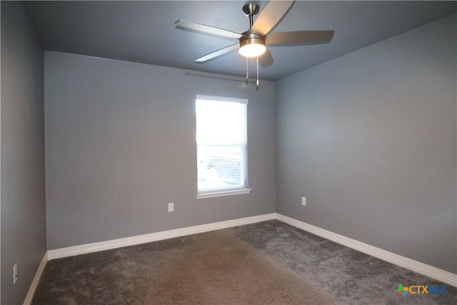 empty room featuring ceiling fan, dark colored carpet, and baseboards