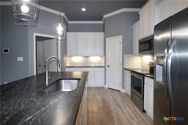 kitchen featuring light wood-style flooring, appliances with stainless steel finishes, white cabinets, and a sink