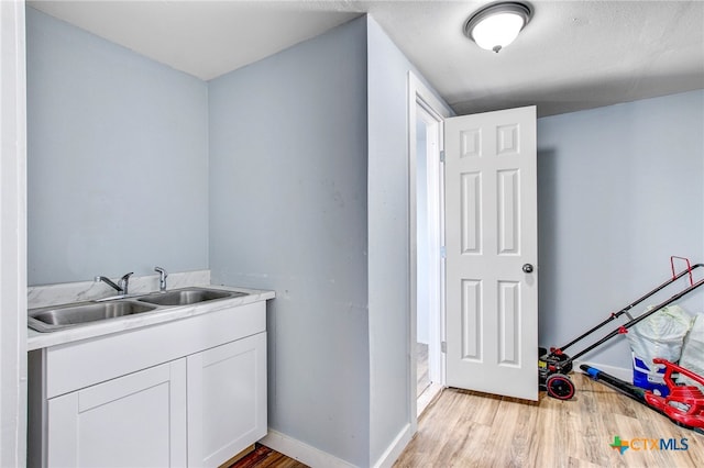 laundry room featuring sink and light wood-type flooring