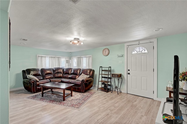 living room featuring light hardwood / wood-style floors and a textured ceiling