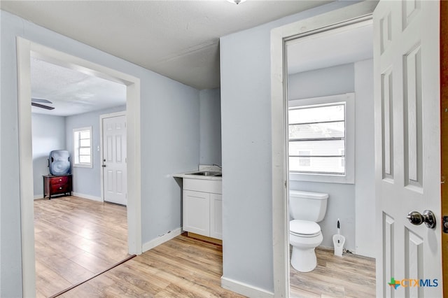 bathroom with vanity, a textured ceiling, ceiling fan, hardwood / wood-style floors, and toilet