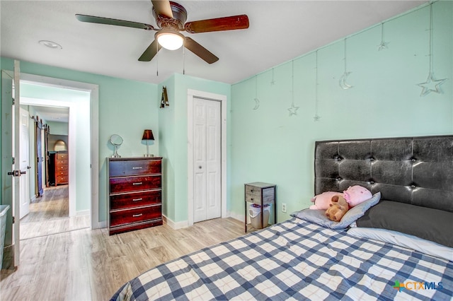 bedroom with a closet, ceiling fan, and light hardwood / wood-style flooring