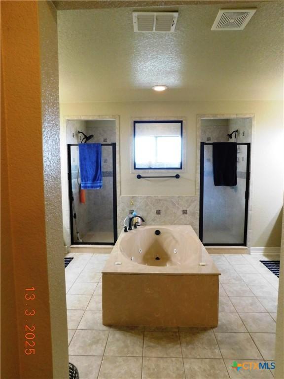 full bathroom with tile patterned flooring, visible vents, and a stall shower