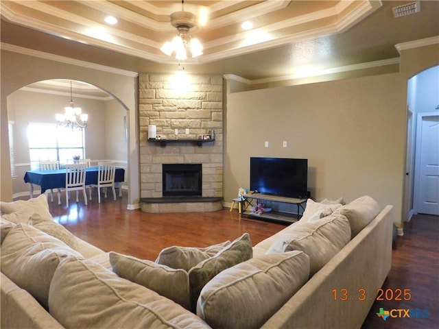 living room featuring arched walkways, visible vents, an inviting chandelier, and wood finished floors