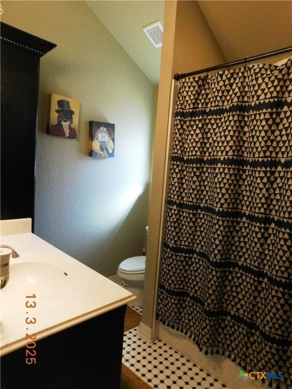 full bathroom with vanity, vaulted ceiling, toilet, and visible vents