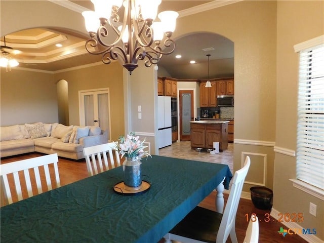 dining room with recessed lighting, arched walkways, crown molding, ceiling fan with notable chandelier, and a raised ceiling