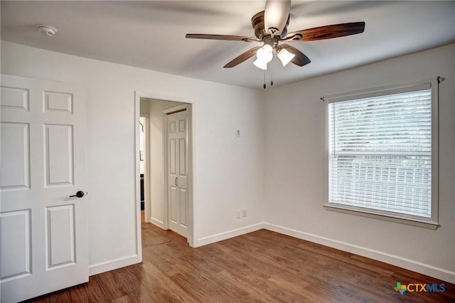416 S Welhausen Ave, Shiner, TX 77984 - unfurnished bedroom with wood finished floors, baseboards, and a ceiling fan