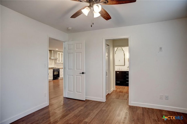 416 S Welhausen Ave, Shiner, TX 77984 - unfurnished bedroom with baseboards, wood finished floors, and a ceiling fan