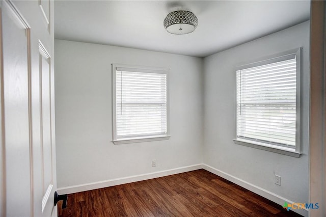 416 S Welhausen Ave, Shiner, TX 77984 - empty room featuring healthy amount of natural light, baseboards, and dark wood-style flooring